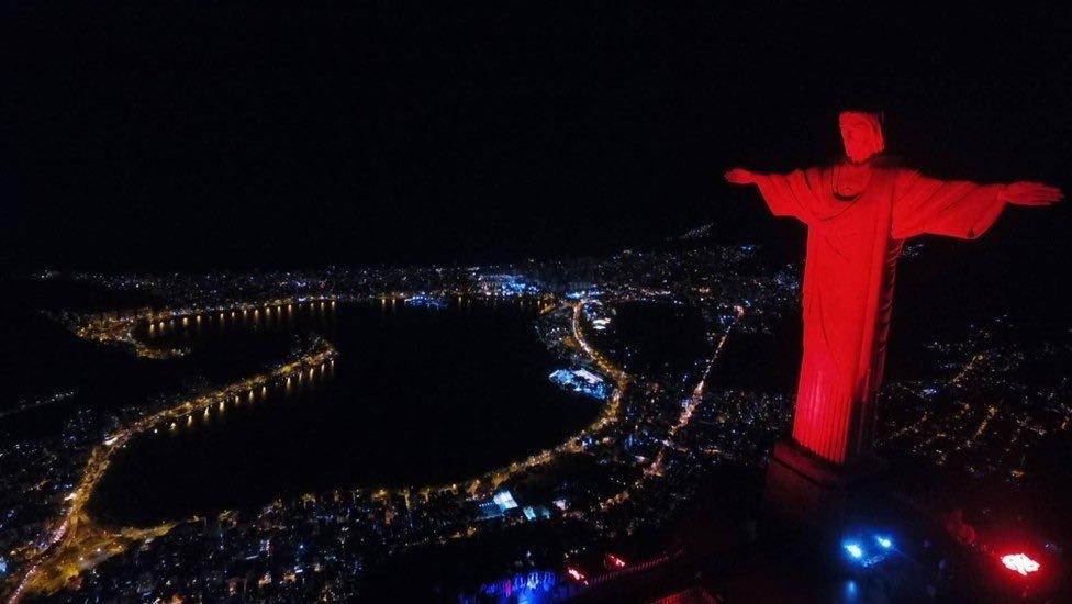 Cristo Redentor é iluminado na cor vermelha pelo ´´Dia Mundial contra o Trabalho Infantil``